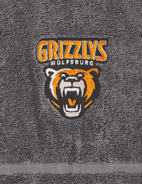 Das Foto zeigt ein Handtuch der Grizzlys Wolfsburg in grau mit aufgesticktem Logo.