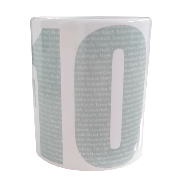 Das Foto zeigt eine weiße Tasse mit grauem Aufdruck "Unser Stolz" und der Nummer 10.